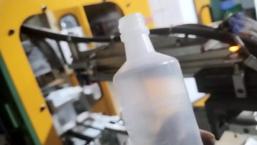 Выдувная машина производит бутылочку для клизмы с манипулятором